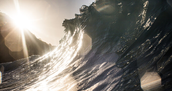 Majestic Golden Hour Wave Crashing Against Rugged Coastal Cliff