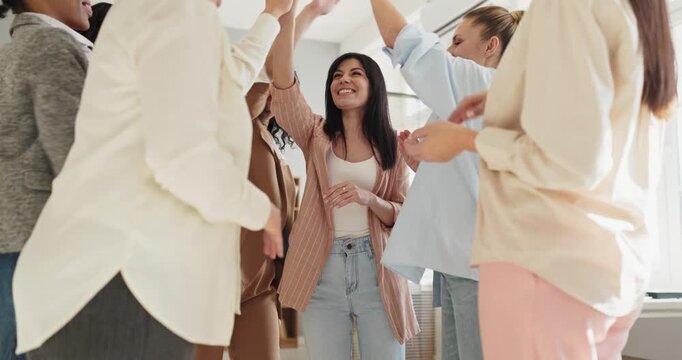 Women team applause celebrates success and motivation. Colleagues high five and clap in a bright office meeting, showing teamwork, coaching and training. Strong concept of teamwork and success.