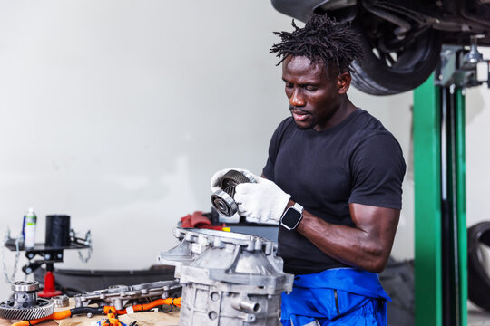 Professional EV Technician Inspecting Electric Drive Unit During Powertrain Service