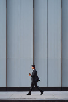Businessman walking on the sidewalk.