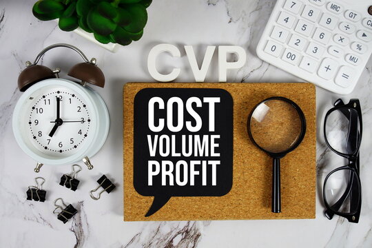CVP - Cost Volume Profit acronym with calculator, alarm clock and magnifying glass, business concept background