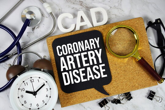 CAD - Coronary Artery Disease acronym with stethoscope, alarm clock and magnifying glass, medical and healthcare concept background