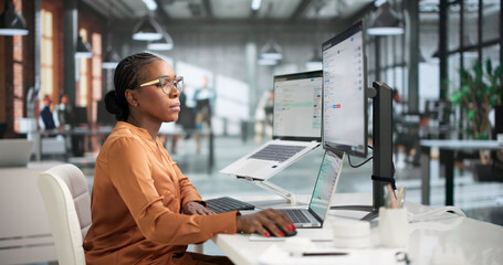 Naklejka premium Young Quality Manager Uses Laptop To Review Audit Reports