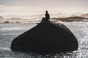 silhouette of a man on a boulder at the sea © SWOF.ph