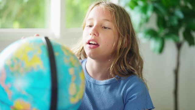 Young school girl studying world geography with globe in classroom exploring continents countries and global knowledge through interactive elementary education learning and childhood curiosity