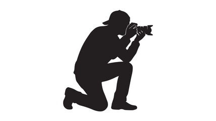 Silhouette of a photographer kneeling with a camera © rockbd