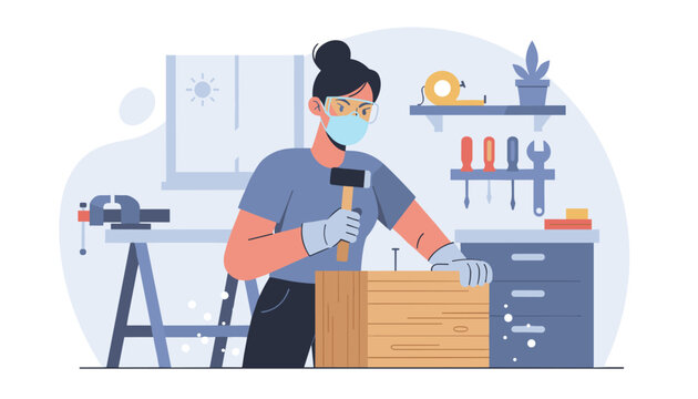 Female carpenter wearing a face mask and safety glasses hammers a nail into a wooden box in a workshop.