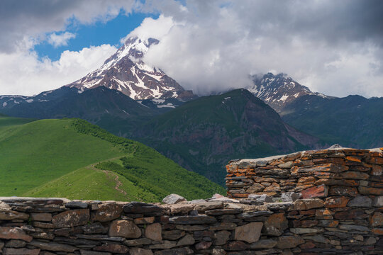 Ancient stone wall with majestic Mount Kazbek view in Georgia with copy space