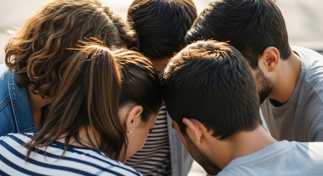 Diverse group of young friends huddled together in a circle.