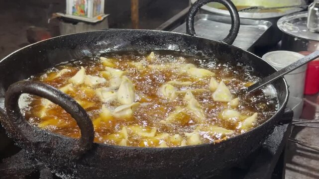 Traditional Indian Samosas (Singara) Deep Frying in Hot Oil at Street Food Stall

