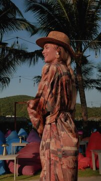 Stylish woman in bikini and lightweight beach kimono  at luxury resort.