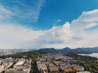 Aerial shot of Hangzhou city, West Lake and surrounding mountains framed under white clouds © feng