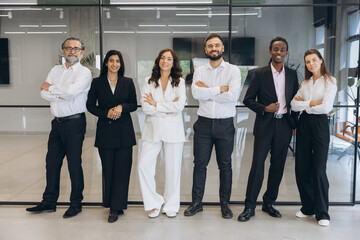 Obraz premium Business professionals line up, crossing arms and smiling, showcasing teamwork and collaboration in a corporate setting