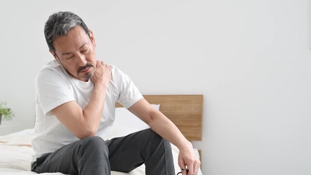 肩を押さえて痛がる50代の日本人男性