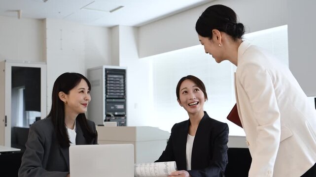 会議で笑顔を見せながら打ち合わせをする20代から40代の日本人ビジネスパーソン3人