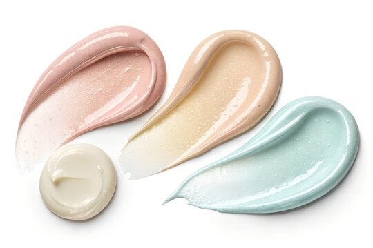 Three distinct cosmetic cream smears in pastel pink beige and light blue shades arranged artistically on a pure white background for professional beauty product marketing photography