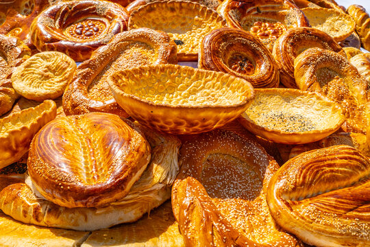 Traditional Central Asian round flatbread piled at Tajik market stall, authentic street food and bakery concept
