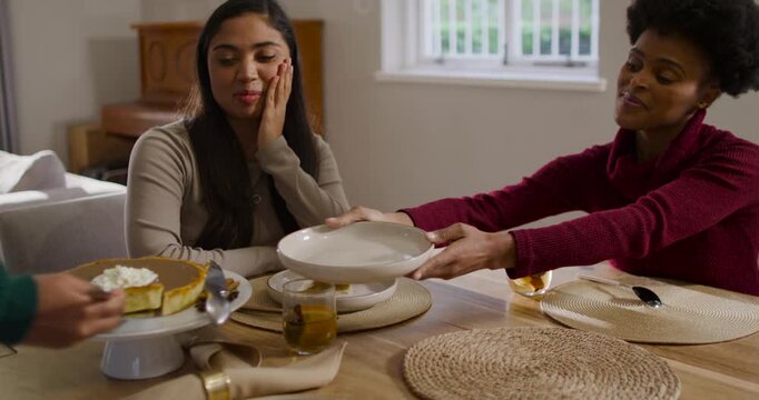 African American mom and daughter watching server serving pumpkin pie slice at table for dessert