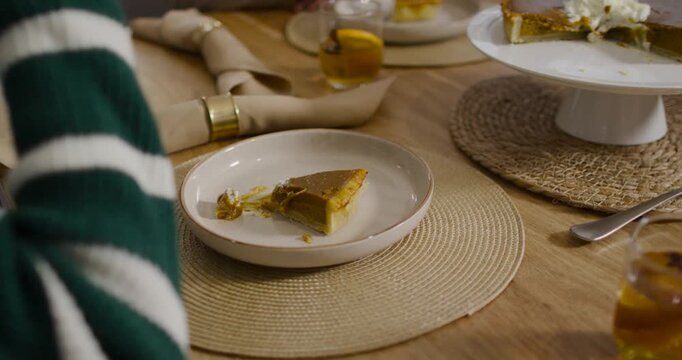 African American woman reaching spoon to cake stand, topping pie slice at table, copy space