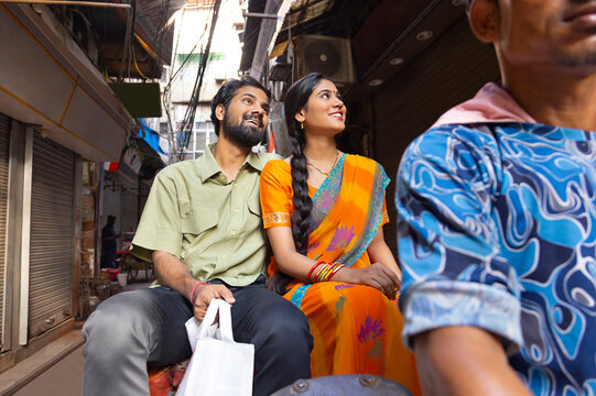 Portrait of happy young couple sitting on a rickshaw