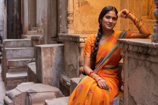 Portrait of young woman sitting at door step