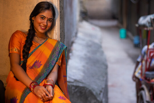 Portrait of young woman sitting at door step