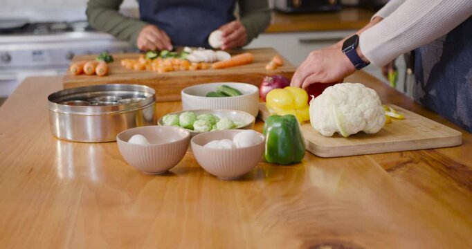 Preparing meal, African American couple chopping vegetables on board using chef knife in kitchen