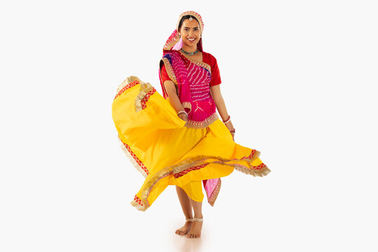 Portrait of Rajasthani woman dancing against white background
