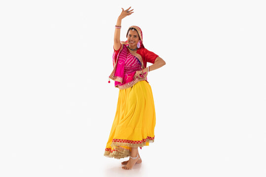 Portrait of Rajasthani woman dancing against white background