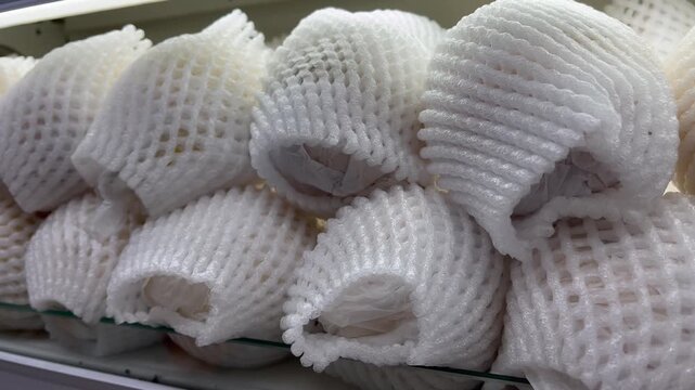 Fresh raw fruits wrapped in white protective foam net packaging