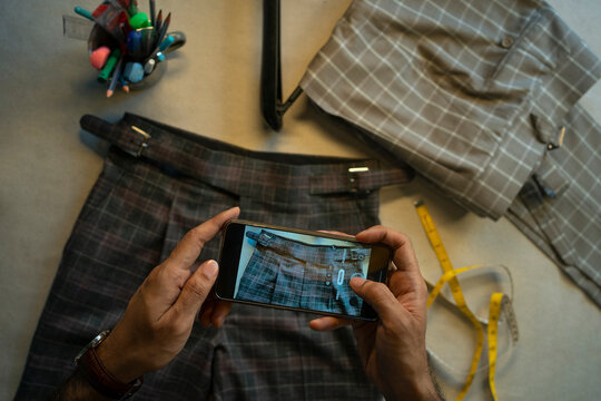 A young professional photographing his clothing collection