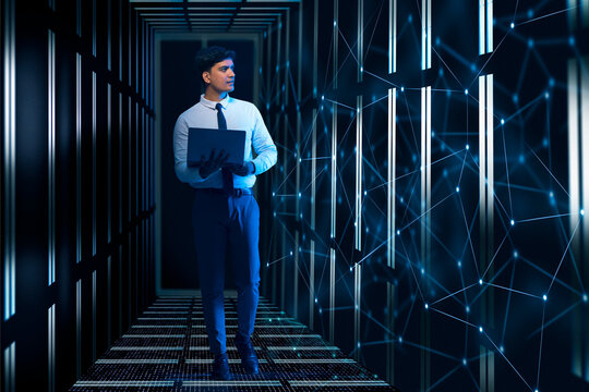 Technician/programmer holding a laptop in the server/data  room