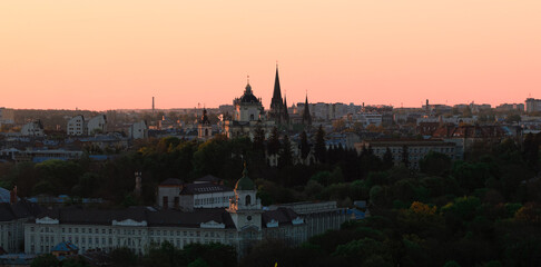 Fototapeta premium Panoramic view of an old European city skyline at sunset with cathedral domes