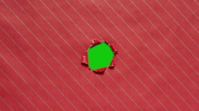 Christmas wrapping paper tears from the center on a green background. Stop motion. Layout for discounts, text, etc