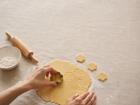 Momento de hacer galletas con masa estirada y cortadores de flores en la mesa