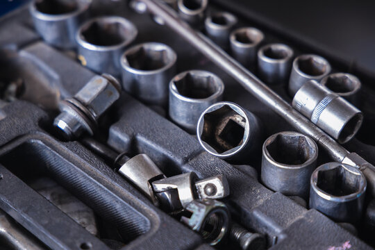 Metallic socket wrench set inside a mechanic toolbox. Assorted professional auto repair tools, garage equipment, and hardware instruments for vehicle maintenance and mechanical fixing