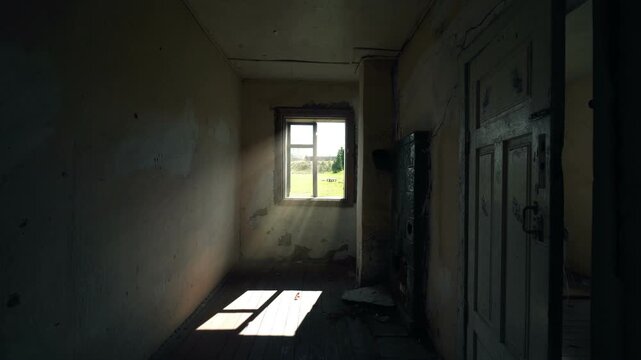Sunbeams stream through a window into a dark abandoned room, revealing peeling walls, a worn wooden floor, and an old stove in a neglected rural interior
