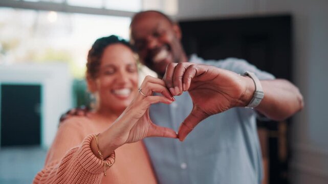 Happy, home and heart hands with love for commitment, relationship or romance together. Man, woman or like emoji with smile, symbol or shape for romantic gesture, partnership or loyalty in house