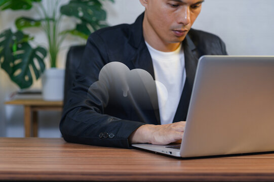 Young Man Working on Cloud Computing Laptop in Office Environment