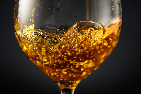 White wine of rich amber color being poured into a glass.