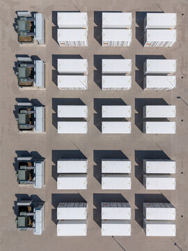 Aerial view of the Olsterdwarspad battery energy storage system with rows of white containers and wind turbines, Dronten, Flevoland, The Netherlands