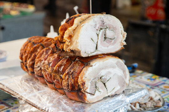 Crispy porchetta roast with golden crackling served at a Ballaro market stall in Palermo, Sicily.
