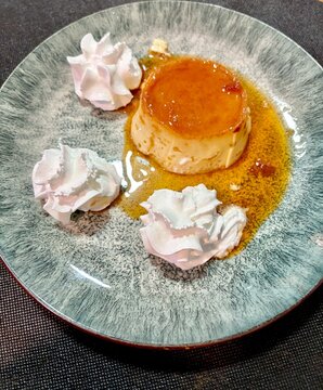 Flan de huevo casero con nata sobre un plato de dise&ntilde;o