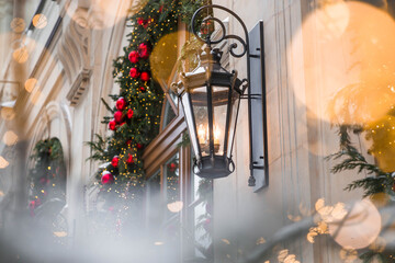 Fototapeta premium Beautiful Christmas background. Lantern and Christmas decorations on a building background. New Year 2027 decoration concept.