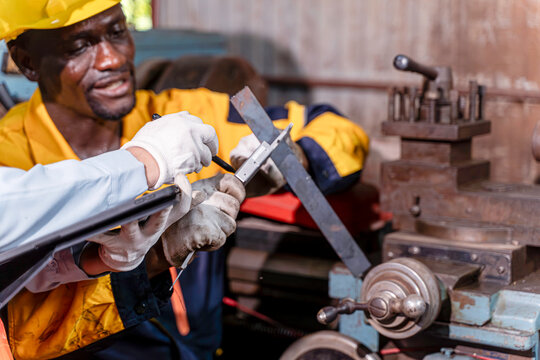 Closeup and clop hand of industrial engineer teamwork in uniform checking old model lathe and drilling machine with tablet at industrial workshop.,