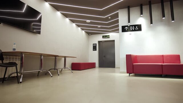 spacious entrance lounge featuring minimalist grey walls and navigation signs. Tidy organized environment suggests professional style