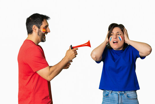 Soccer fans celebrating and reacting aggressively with an air horn during a sports rivalry