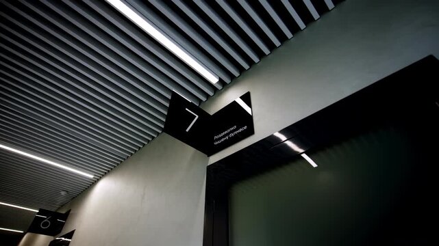 Contemporary glass door frame and informative hallway navigation plates. Minimalist design creates organized businesslike atmosphere