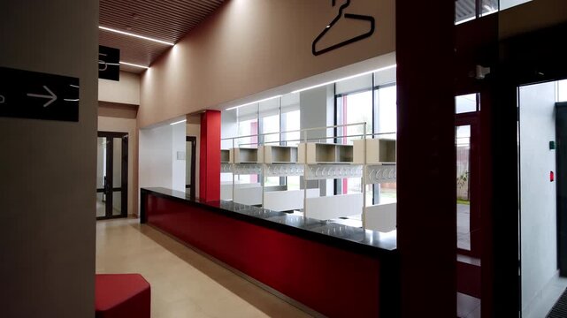 Modern entryway features glass exit doors and informative directional navigation signs. Tidy minimalist design creates organized atmosphere