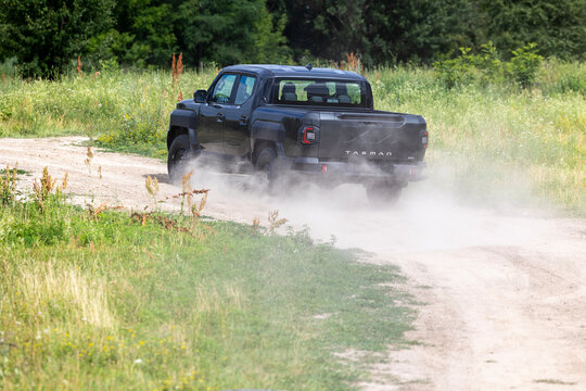 Lisnyky, Kyiv Region, Ukraine - Jul 11, 2026: A new Kia Tasman all-wheel-drive pickup truck undergoing a dynamic test drive on a dusty rural road, showcasing its off-road capabilities Detailed visual